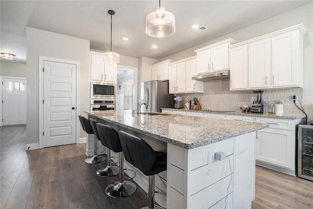 2320 Ridge View Dr, Loganville, GA 30052 - kitchen with appliances with stainless steel finishes, under cabinet range hood, decorative backsplash, white cabinetry, and recessed lighting