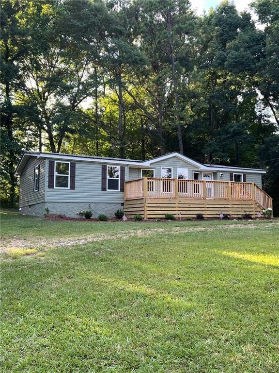 manufactured / mobile home featuring a front lawn and a deck