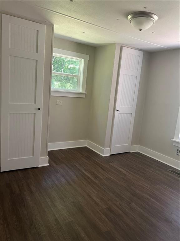 empty room with dark wood-type flooring