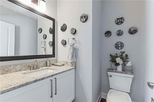 half bathroom with vanity and toilet