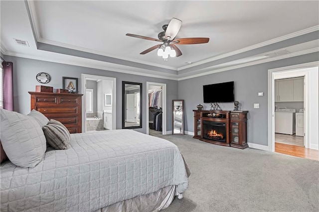 bedroom featuring a walk in closet, washing machine and clothes dryer, visible vents, carpet flooring, and baseboards