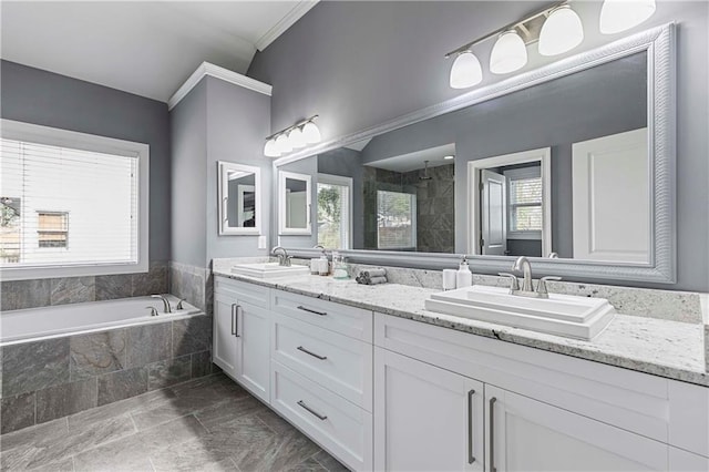 bathroom with double vanity, tiled shower, a sink, and a bath