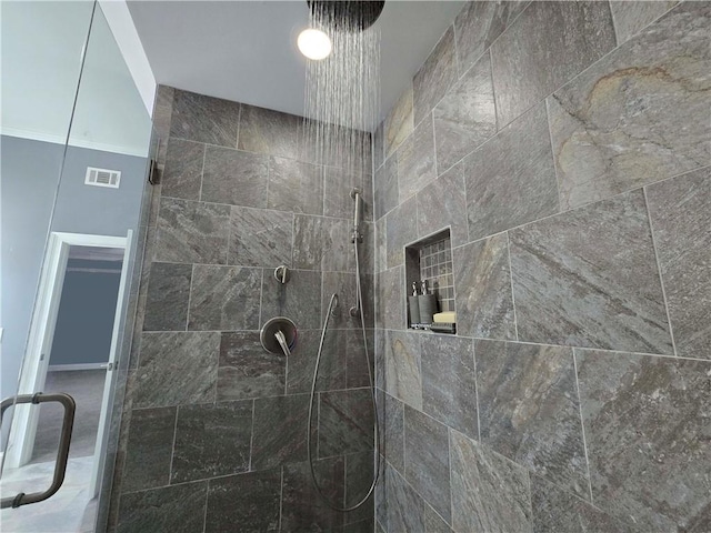 full bath featuring a tile shower and visible vents