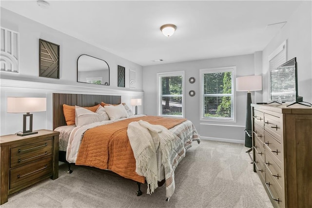 bedroom featuring light carpet and baseboards