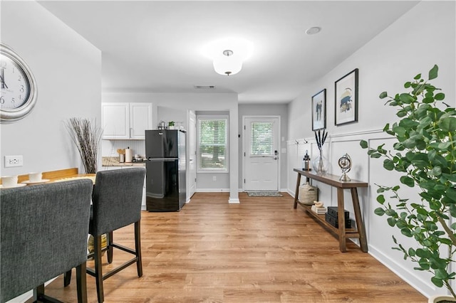 entryway with light wood-style flooring and baseboards