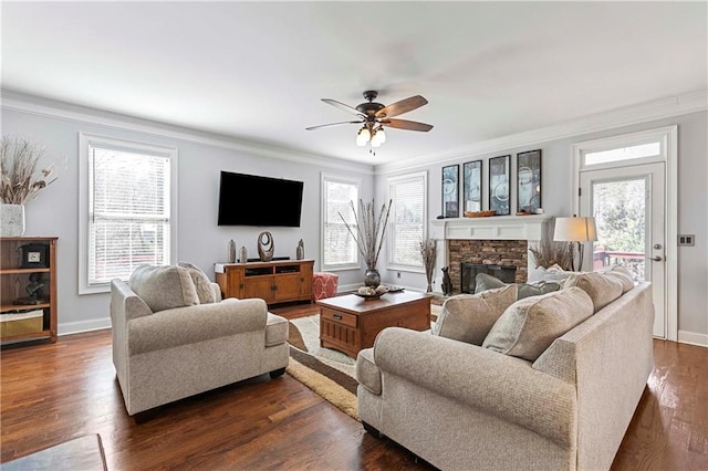 living area with crown molding, dark wood-style flooring, and a healthy amount of sunlight