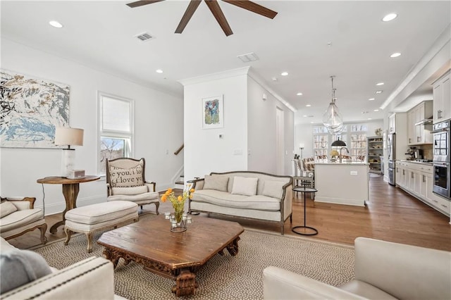 living room with visible vents, ceiling fan, stairway, recessed lighting, and wood finished floors