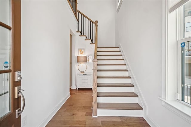 staircase featuring baseboards and wood finished floors