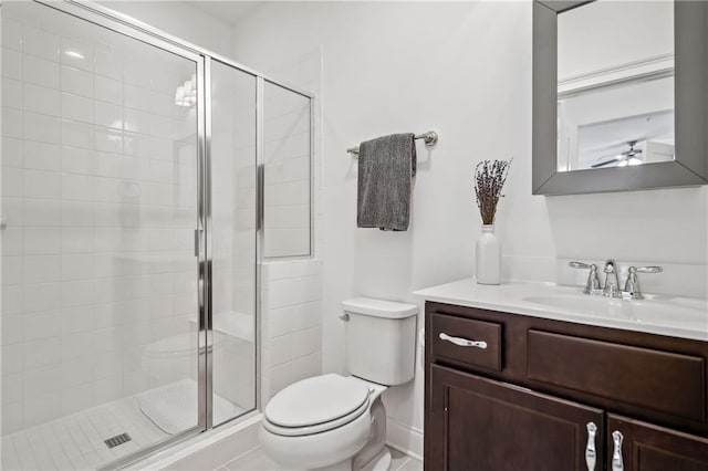 bathroom with a stall shower, toilet, and vanity