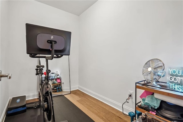 workout area featuring baseboards and wood finished floors