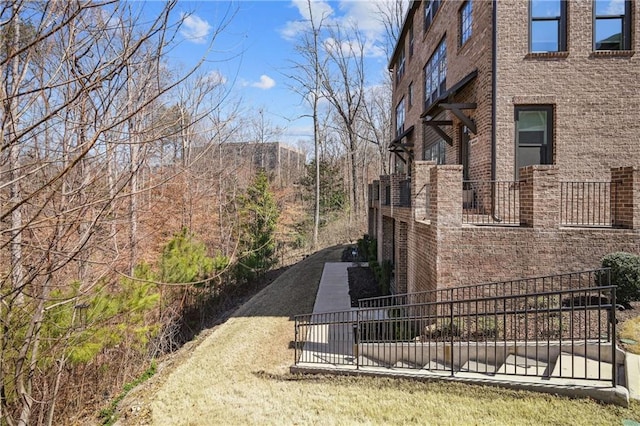 view of side of home with brick siding and dirt driveway