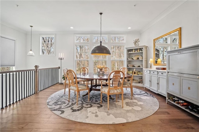 dining area with plenty of natural light, wood finished floors, and ornamental molding