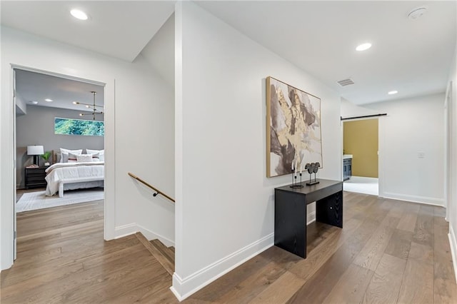 hallway featuring a barn door and hardwood / wood-style floors