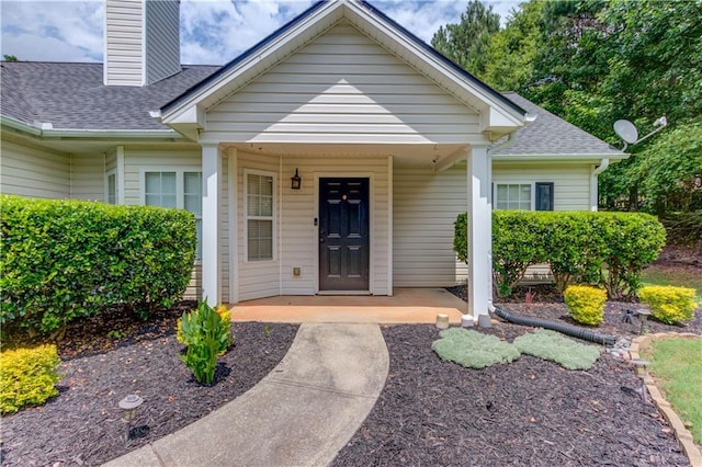 926 Masters Dr, Monroe, GA 30655 - entrance to property featuring a chimney, a shingled roof, and a porch