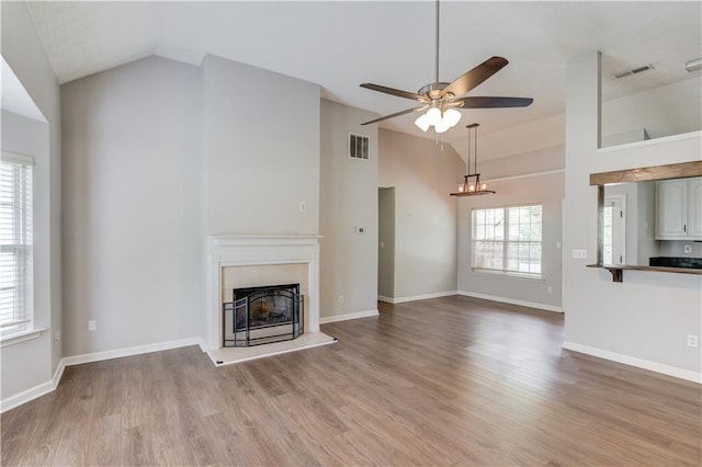 926 Masters Dr, Monroe, GA 30655 - unfurnished living room featuring a fireplace with raised hearth, a ceiling fan, light wood-style floors, and high vaulted ceiling