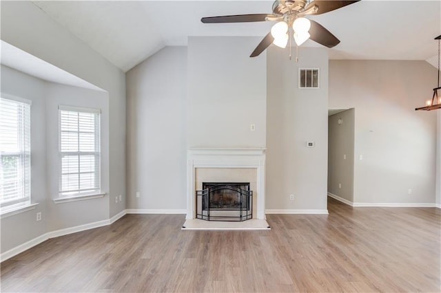 926 Masters Dr, Monroe, GA 30655 - unfurnished living room featuring ceiling fan, wood finished floors, a fireplace with raised hearth, a chandelier, and high vaulted ceiling