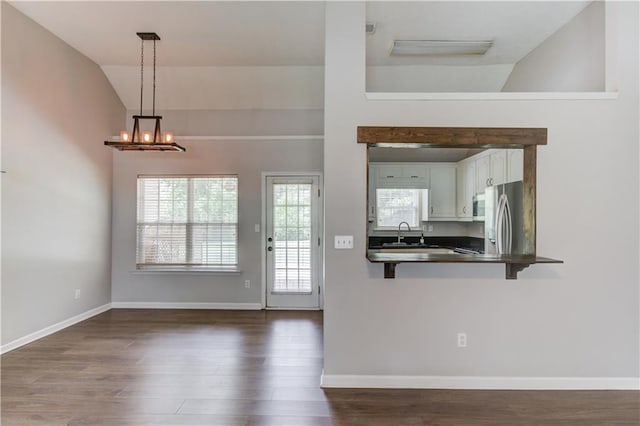 926 Masters Dr, Monroe, GA 30655 - kitchen featuring dark countertops, lofted ceiling, stainless steel appliances, dark wood-style flooring, and a kitchen breakfast bar