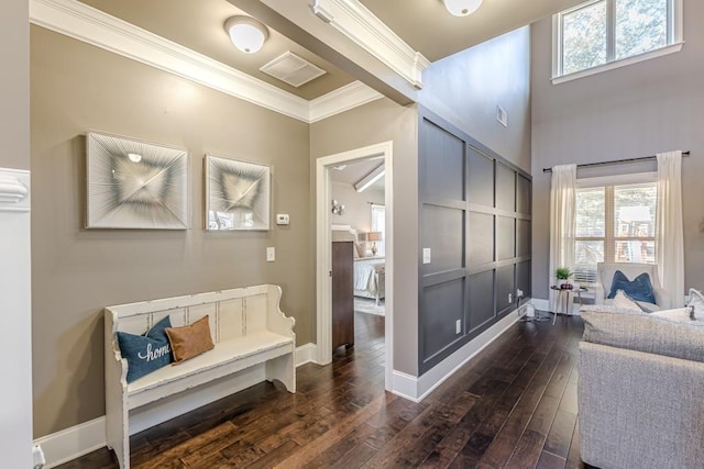 corridor with a wealth of natural light, crown molding, and dark wood-type flooring