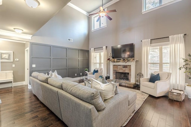 living room featuring a fireplace, dark wood-type flooring, and a wealth of natural light