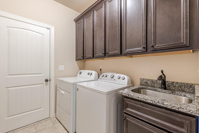 laundry area with cabinets, independent washer and dryer, light tile patterned floors, and sink