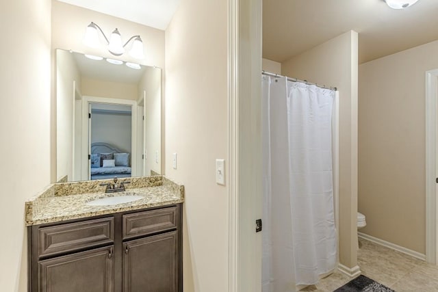 bathroom with toilet, vanity, and tile patterned floors