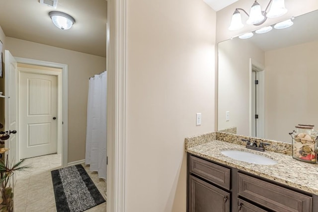 bathroom with tile patterned flooring, vanity, and a chandelier