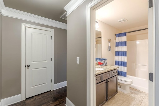 full bathroom featuring shower / bathtub combination with curtain, tile patterned floors, toilet, vanity, and ornamental molding