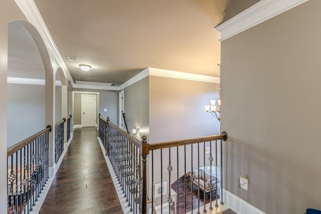 corridor featuring dark hardwood / wood-style floors, crown molding, and a chandelier