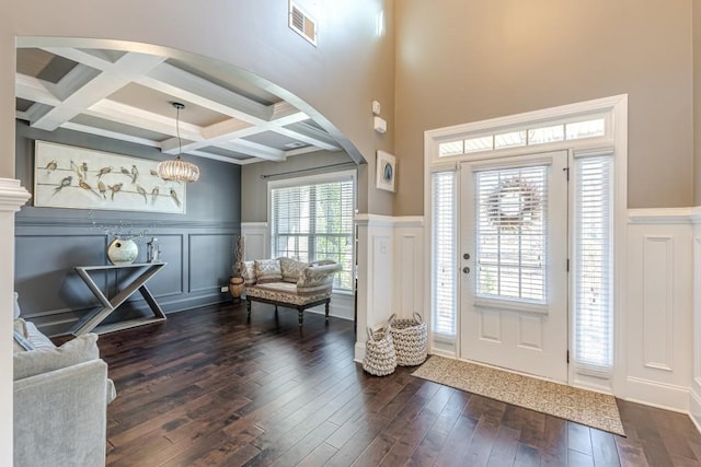 entryway featuring a chandelier, beamed ceiling, dark wood-type flooring, and coffered ceiling