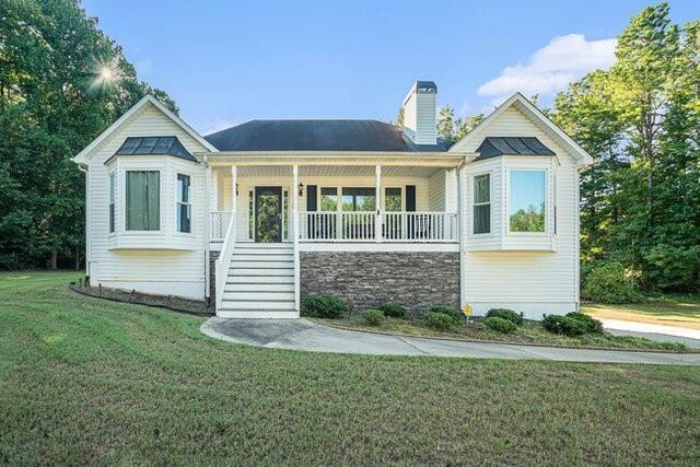 view of front of house with covered porch and a front yard