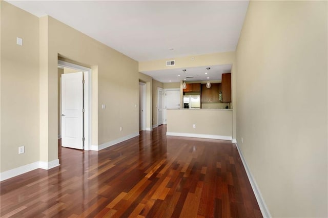 unfurnished living room with dark wood-style floors and baseboards