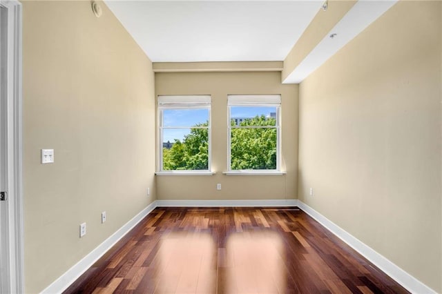 unfurnished room featuring dark wood-style flooring and baseboards