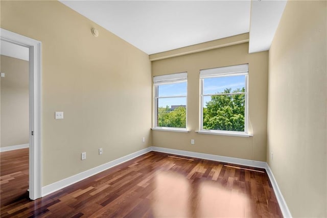 empty room featuring wood finished floors and baseboards