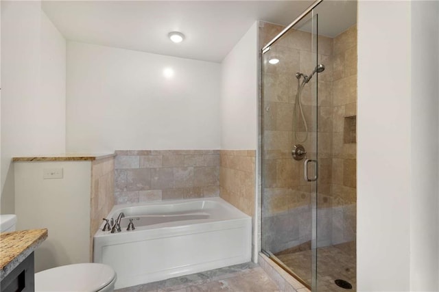 full bathroom with a stall shower, a bath, toilet, and vanity