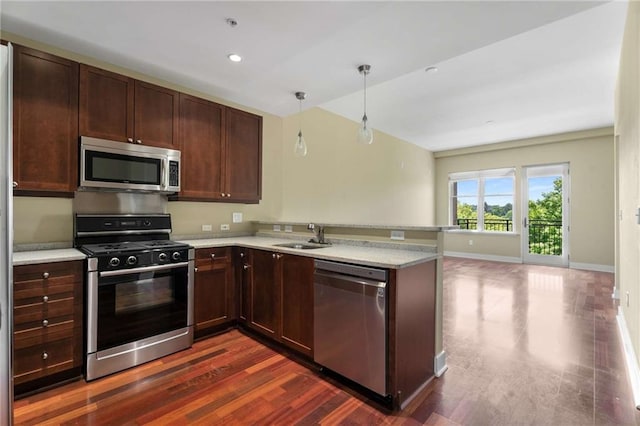 kitchen with stainless steel appliances, dark wood-style flooring, a peninsula, pendant lighting, and baseboards