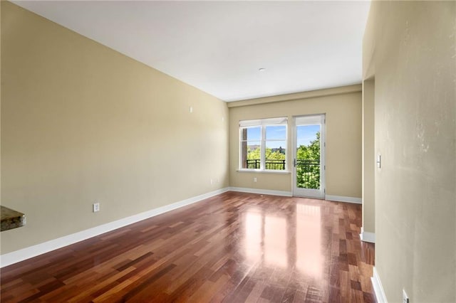 unfurnished room with wood finished floors and baseboards
