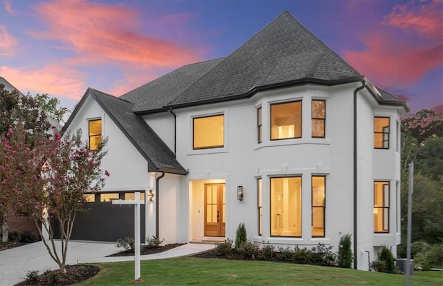 view of front of house with a garage and a yard