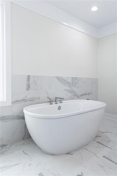 bathroom featuring tile walls and a bathtub