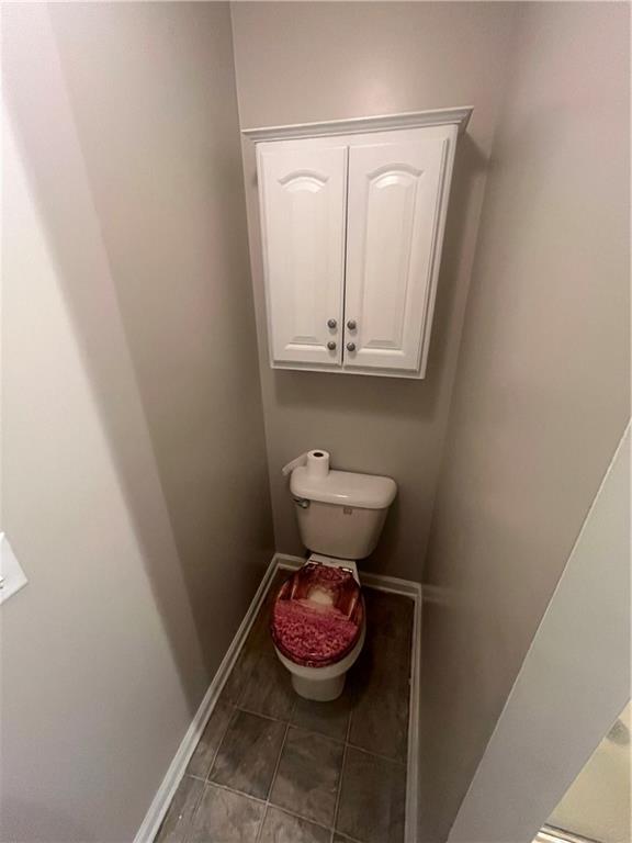 bathroom featuring baseboards, toilet, and tile patterned floors