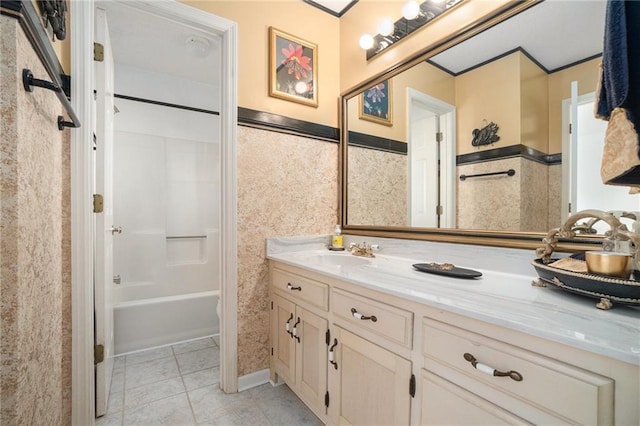 bathroom with tile patterned flooring, tub / shower combination, tile walls, wainscoting, and vanity