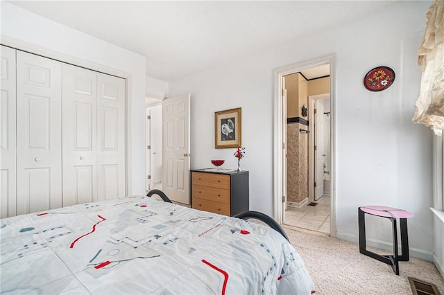 bedroom featuring visible vents, ensuite bath, a closet, carpet floors, and baseboards