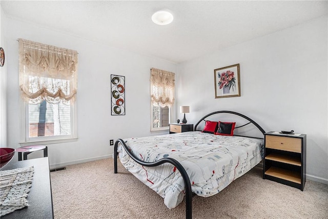 carpeted bedroom featuring visible vents and baseboards