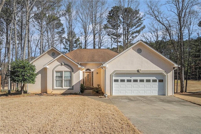 single story home with a garage, driveway, and stucco siding