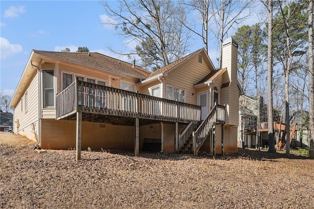 back of house with a wooden deck, a chimney, and stairs