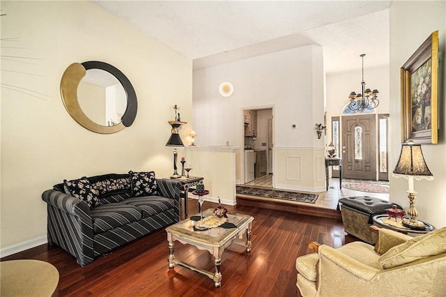 living area featuring hardwood / wood-style flooring, baseboards, and a chandelier