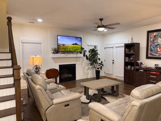 living room with wood-type flooring and ceiling fan