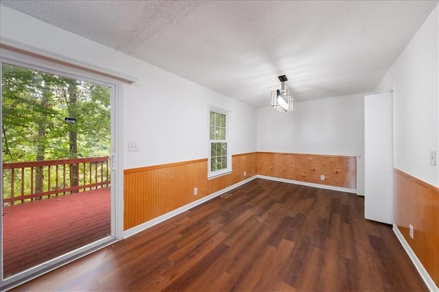 spare room featuring dark hardwood / wood-style flooring and a textured ceiling