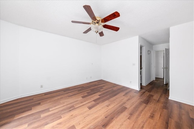 empty room featuring ceiling fan, a textured ceiling, and dark hardwood / wood-style flooring