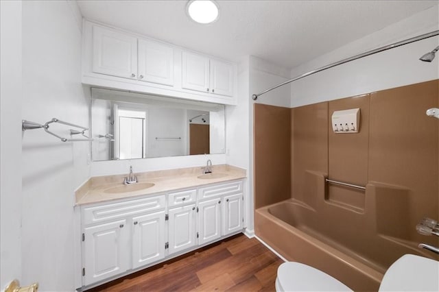 full bathroom featuring toilet, hardwood / wood-style flooring, vanity, and washtub / shower combination