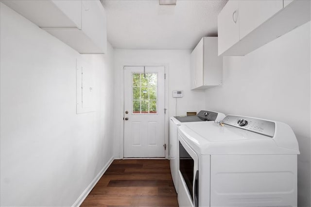 clothes washing area with dark wood-type flooring, cabinets, and washer and clothes dryer